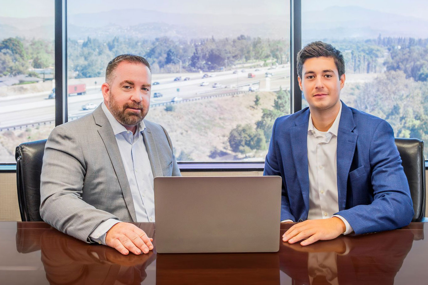 Photo of Jim and Noah sitting at a table in a conference room.